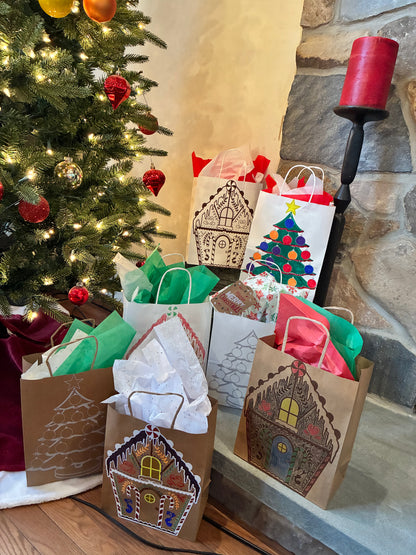 Gift bags with house designs in front of a decorated Christmas tree and fireplace.