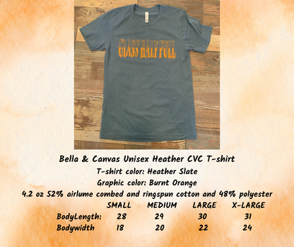 Bella Canvas Unisex Heather CVC T-shirt. Color is heather slate blue with a burnt orange graphic saying "Glass Half Full"